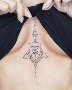 a woman's back with a tattoo design on her stomach and the bottom part of her chest