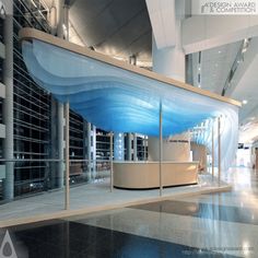 an empty lobby with a curved counter and blue wave design on the wall behind it