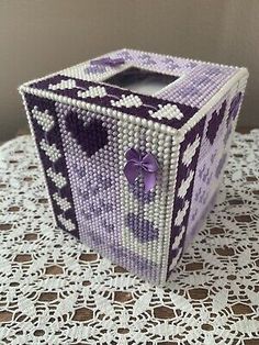 a purple and white beaded box on a table