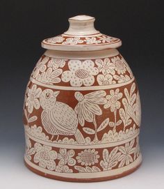 a brown and white vase with flowers on it