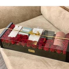 a box filled with roses sitting on top of a couch