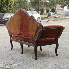 an old chair sitting in the middle of a parking lot