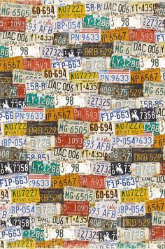 many different license plates are stacked together on a wall with numbers and letters all over them