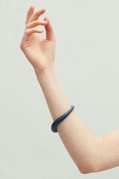 a woman's arm with a bracelet on it and her hand in the air