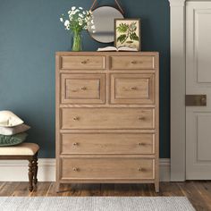 a wooden dresser sitting next to a blue wall