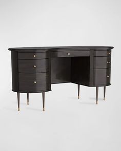 a black desk with three drawers and two gold knobs on the top, in front of a white background