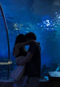 two people standing in front of an aquarium