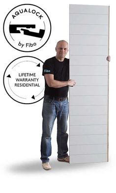 a man standing next to a tall white board