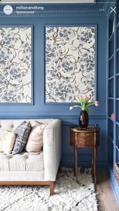 a living room with blue painted walls and furniture in the corner, including a white couch