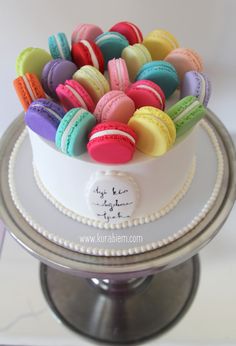 there is a cake decorated with colorful macaroons