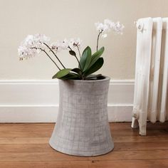 there is a planter with flowers in it on the floor next to a radiator