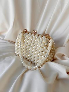 🌟 Elevate your style with this exquisitely crafted handbag adorned with pearl details. 🌟 Handcrafted with care, this bag is designed to add a touch of sophistication to every moment. The elegance of the pearl embellishments sets this bag apart, transforming it into a unique accessory. 🌸 Why Choose This Bag? 🌸 More than just an accessory, this bag is an opportunity to reflect your style and grace. Whether for a special event or to enhance your daily chic, this pearl-adorned bag complements ev Cream Evening Bag With Pearl Handle, Pearl Evening Bag With Pearl Handle For Wedding Guest, Cream Bags With Pearl Embroidery For Events, Beige Clutch Evening Bag With Pearl Handle, Handmade Pearl Evening Bag In Cream, Beige Rectangular Evening Bag With Pearl Handle, Cream Rectangular Bag With Pearl Embroidery, Beige Pearl Evening Bag For Events, Handmade Cream Pearl Evening Bag