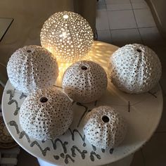 some white balls are sitting on a table with a light in the middle of them