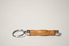 a wooden keychain with two metal rings on it's ends and a wood handle