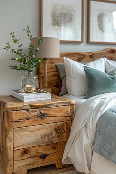 a bed with two framed pictures on the wall above it and a wooden dresser next to it