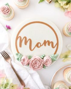 a mother's day cake surrounded by cupcakes and flowers