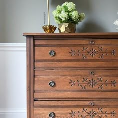 a wooden dresser with flowers on top of it