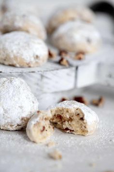 powdered sugar covered cookies are sitting on a tray with other pastries in the background