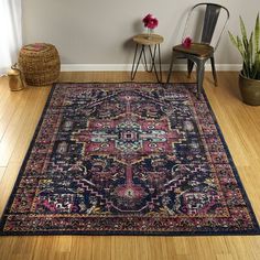 a large rug in the corner of a room next to a chair and table with flowers on it