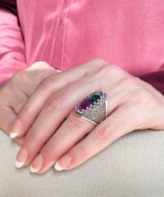 "This stunning ring is crafted from 925 sterling silver and showcases a beautiful cabochon cut natural ruby zoisite gemstone. This bold ring length is 1.00\" width is 0.40\", and the gemstone measures 8x22 mm, cabochon oval-cut. It can be used as a knuckle ring. The ring is highly polished and features an attractive oxidized finish. It comes with a velvet pouch, silver polish cloth, and a luxurious gift box, making it the perfect gift for that special someone in your life.          A beautiful and unique ring for her, perfect for special occasions or everyday use. The lovely cabochon cut green - red ruby zoisite stone is beautifully cut and set in sterling silver, with intricate ornament design filigree around the edge with exceptional embroidery lace details. A perfect option for Mother's Luxury Silver Ruby Cabochon Ring, Silver Oval Emerald Ring With Multi-stone, Oval Silver Emerald Ring With Multi-stone, Oval Emerald Ring In Silver With Multi-stone, Elegant Oval Ruby Ring With Natural Stones, Cabochon Ruby Ring As Gift Fine Jewelry, Cabochon Ruby Ring Fine Jewelry Gift, Fine Jewelry Ruby Cabochon Ring Gift, Sterling Silver Oval Cabochon Multi-stone Jewelry