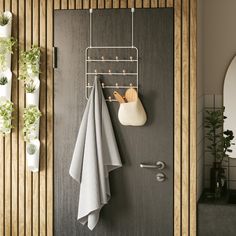 a towel rack is hanging on the wall next to a door with potted plants