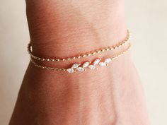 Our Crystal Vine and Dot Bracelets have been top sellers in our shop for bridesmaids, birthdays, thank you gifts, and every day gifts. The Vine is made with cubic zirconia crystals and 18k gold. The Dot is made up of small dainty discs connected together, both bracelets are 18k gold, rhodium, or rose gold plating over brass. Classic minimalist designs that can be dressed up, but also durable for everyday wear. Bracelets measures 6" long with a 1.5" adjustable ending, they can be connected anywhere from 6-7.5". The crystal vine portion is also slightly curved for comfort. This bracelet is handmade in our shop and packaged into our Tom Design logo stamped boxes. Enter a gift message at checkout and add on a bow to send directly to your recipient. See our other listings: www.tomdesign.etsy.co Layering Bracelets, The Dot, Bracelet Dainty, Minimalist Designs, Stackable Bracelets, Dainty Bracelets, Saint George, Layered Bracelets, Gift Message