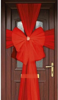 a red curtain is hanging over a door with a bow at the top and bottom