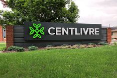 a large sign that says centlivre in front of some trees and grass on a cloudy day