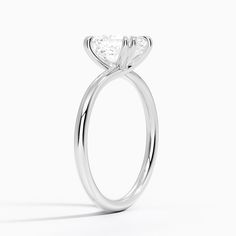 a white gold ring with a pear shaped diamond in the center, on a white background