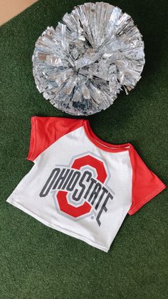 Take your game day style to the next level with our Ohio Crop Baby Tee, perfect for college game day! Its stretchy fabric makes it the perfect option for a comfy game-day look. Ohio crop tee White/Red Baby tee 95% Polyester, 5% Spandex. Cropped Fit Measurements/Sizing: (Approximate. Measured lying flat.) **2-3" stretch throughout. S- Bust 30" Length 14 1/2" M-Bust 32" Length 15" L- Bust 34" Length 15 1/2" Model Specs: Emily is wearing a size small in the photo.How will this item fit you? Check out our MODEL SPECS (Typical Sizing - Karli: S-Size 5/26 - 5ft 2in, Emily: S-Size 3/25 - 5ft 5in, Syd: L/XL- Size 15/ - 5ft 8in)Need help with sizing? No problem! Join our VIP group on Facebook, Everyday Chic Boutique VIP Insiders to chat directly with our team and other customers just like you.Packa Varsity Tops For Cheerleading During Football Season, Team-colored Tops With Team Logo For Cheerleading, Team-colored Cheerleading Tops With Team Logo, Casual Game Day Tops With Logo Print, Sporty Tops For Football Season Fan Gear, Casual Tops With Logo Print For Game Day, Sporty Football Season Fan Gear Tops, Varsity Cotton Top For Football Season, Varsity Tops With Team Name For Fan Gear