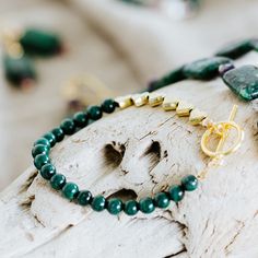 Elegant deep green 4mm malachite beads are finished with 6 gold plated metal hearts. Feel the luxurious weight of the bracelet and enjoy the vibrant beauty of malachite. Length 7" Secures with a gold plated brass toggle clasp. Handmade in Lincoln, Nebraska Green Heart Beads Bracelet Jewelry, Green Heart Beads Bracelet, Hand-strung Gold Malachite Jewelry, Gold Malachite Jewelry Hand-strung, Gold Malachite Bracelet, Spiritual Green Jewelry With Heart Beads, Spiritual Green Heart Beads Jewelry, Metal Hearts, Bracelet Elegant