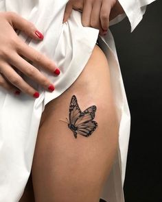 a woman's thigh with a butterfly tattoo on it