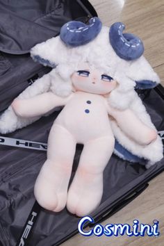 a stuffed animal laying on top of an open piece of luggage with the word cosmini written below it