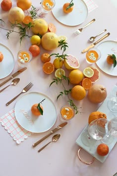 the table is set with oranges, lemons and silverware for an elegant dinner