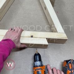 a person is working on some wood with drill and screwdriver next to it