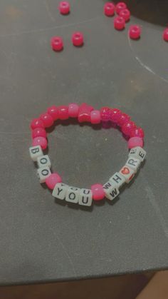 a pink beaded bracelet with words that spell out the word i love you on it