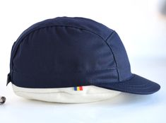 "A navy blue five panel strapback hat, made of medium-weight cotton, with a medium length brim which is unique on the caps market. Out in the woods or in the city, pedal like a madafaca while proudly wearing it. Ride fast through traffic, exercise your body and calm your mind ~ it's also what we believe in. The brim on this model is shorter than most 5 panel hats on the market. In our shop it's considered a medium sized brim (a little bit longer than the kepi brim and a little bit shorter than t Navy Adjustable 5-panel Baseball Cap, Navy Cotton 5-panel Baseball Cap, Navy Baseball Cap With Short Brim For Outdoor, 5 Panel Hat, Calm Your Mind, Five Panel, Panel Hat, Strapback Hats, In The Woods