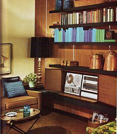 a living room filled with furniture and bookshelves next to a wall full of books