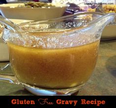 a glass pitcher filled with gravy on top of a table