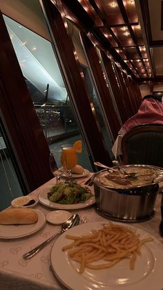 a table full of food and drinks with a view of the city from behind it