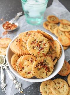 small crackers in a white bowl on a table with spoons and salt shakers