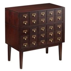 a wooden cabinet with many drawers and brass pulls on the front, along with two legs