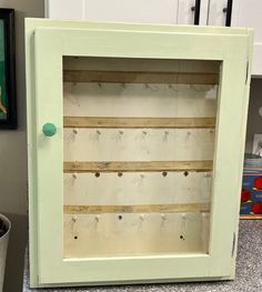 a green cabinet sitting on top of a counter next to a potted plant