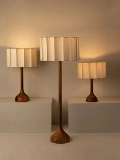 three lamps are sitting next to each other on white blocks and one is turned off