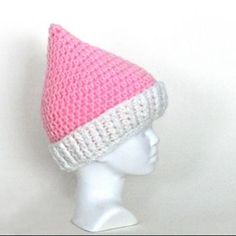 a white mannequin head wearing a pink and white knitted hat