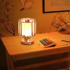 a lamp that is sitting on top of a table next to a book and magazine