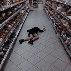 a woman laying on the floor in a grocery store with her legs spread wide open