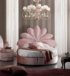 a fancy bedroom with pink furniture and chandelier