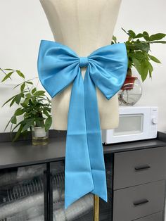 a dress form with a blue bow on it