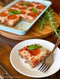 a piece of pizza sitting on top of a white plate next to a knife and fork